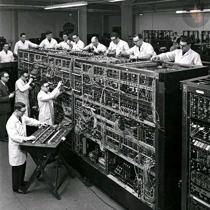 A team of researchers assembling a large early electronic computer.